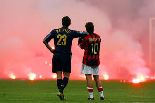 Materazzi et Rui Costa attendent que la fumée se dissipe pour reprendre le derby milanais.