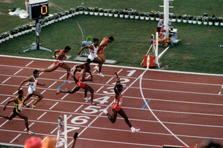 Carl Lewis fête sa victoire avant la ligne sur 100 mètres aux JO 1984 de Los Angeles