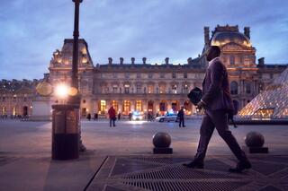 Assane Diop wandelt voorbij het Louvre